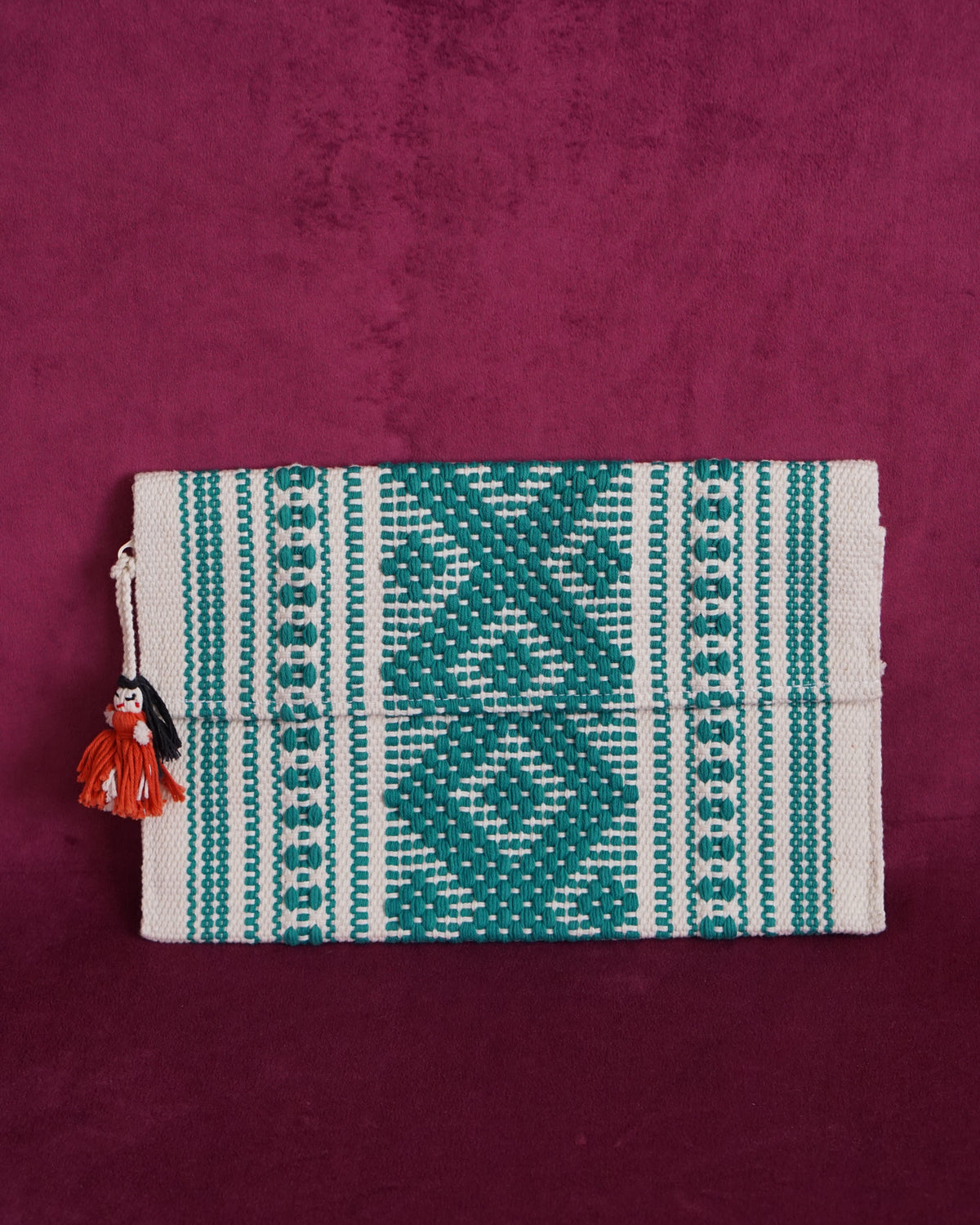 Handwoven cotton clutch in cream and teal with a raised diamond and dot pattern, sourced from Mexico City