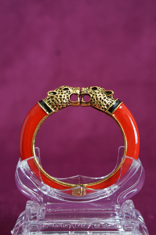 Glossy red enamel hinged bangle capped with two antiqued gold-tone leopard heads