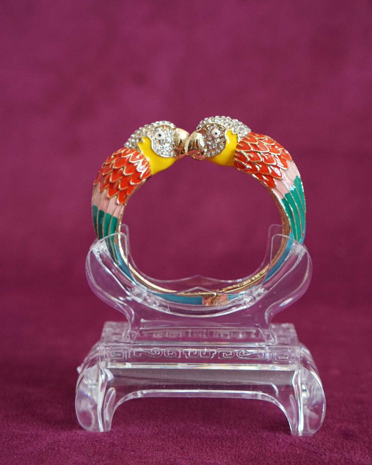 Hinged enamel bangle with two parrots meeting beak to beak, heads paved in sparkling crystals