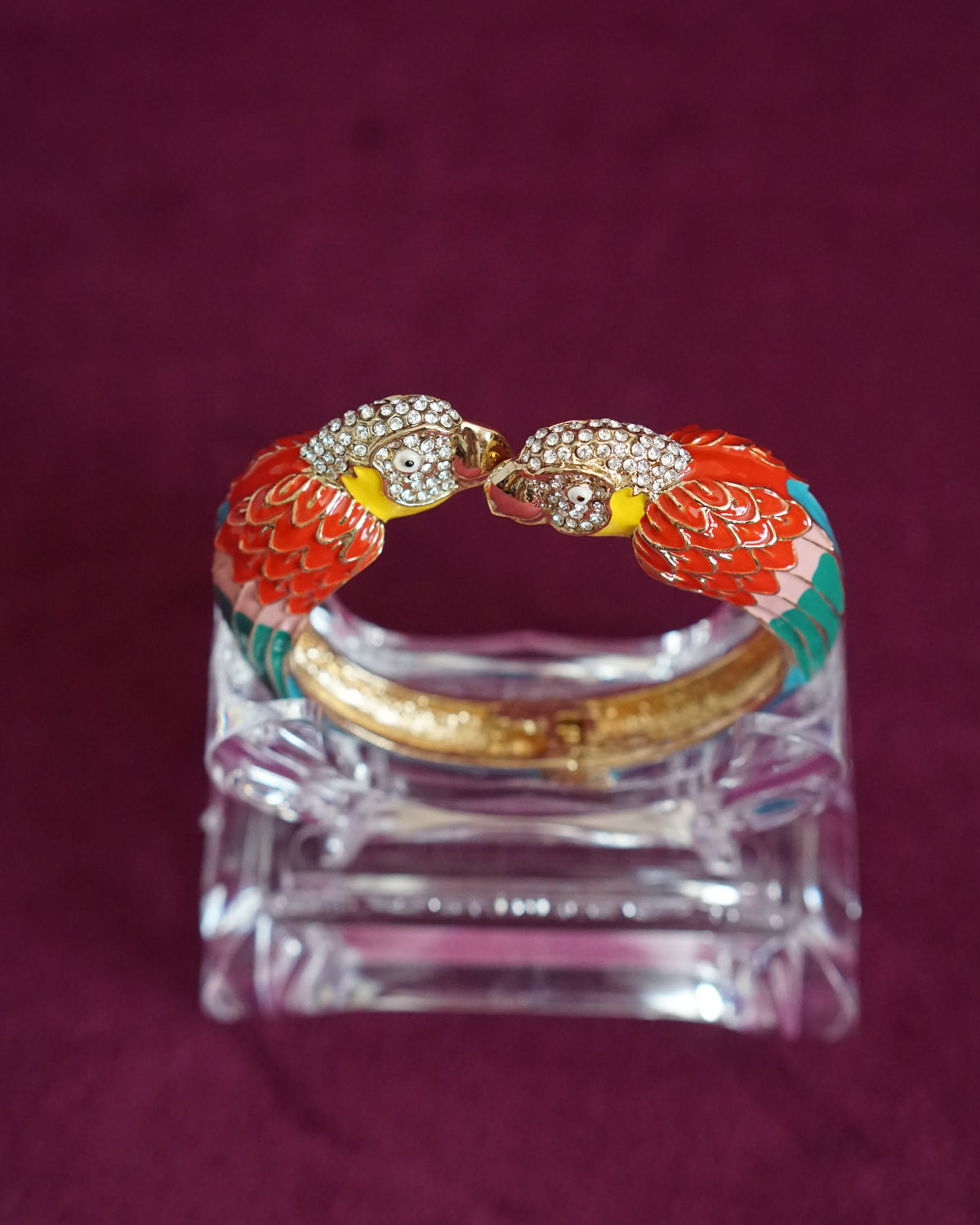 Hinged enamel bangle with two parrots meeting beak to beak, heads paved in sparkling crystals