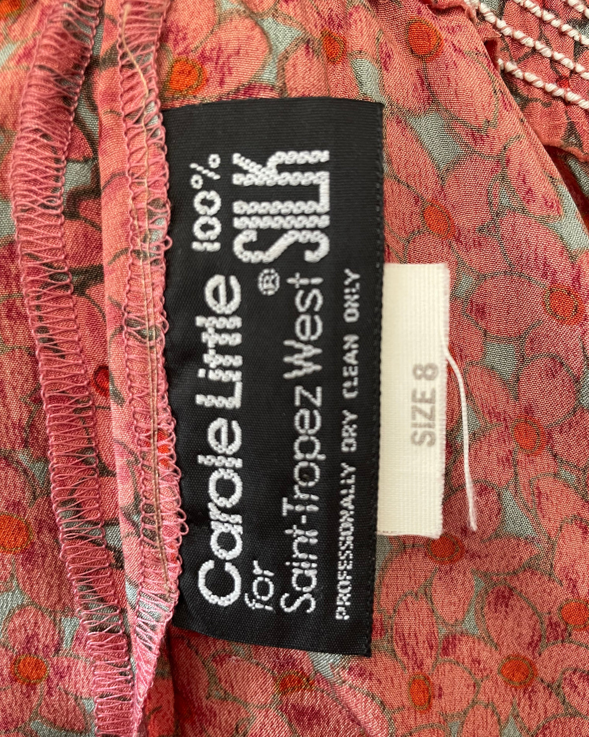 A vintage Carole Little tiered silk skirt with a tropical toucan and floral print in brown, teal, and orange tones, shown against a kraft background