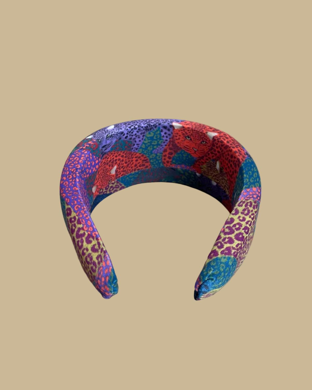 Wide padded Farm Rio headband in a patchwork of jewel-toned leopards in purple, red, teal, and olive