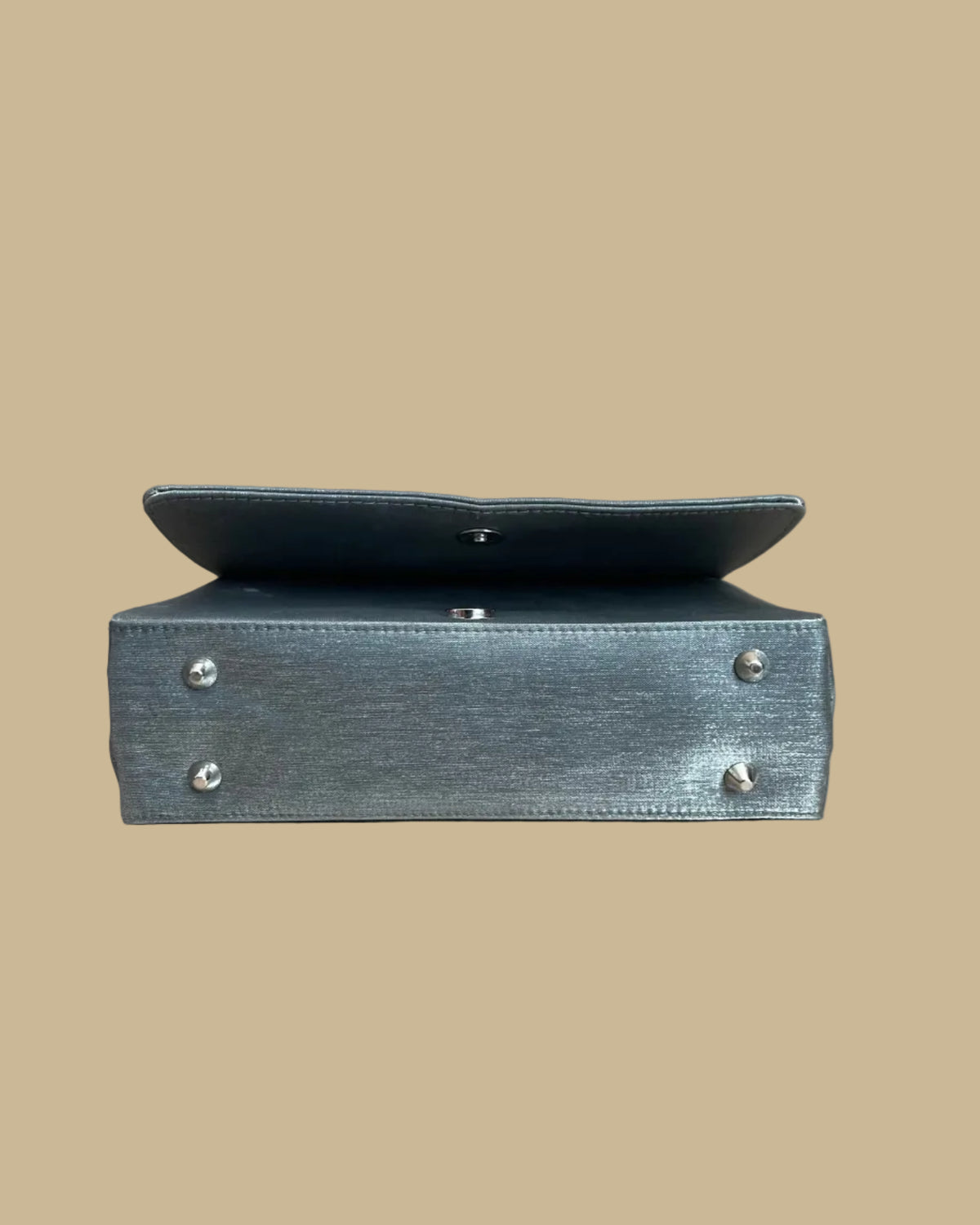 Pewter-silver metallic evening bag with a polished chrome feline handle across the flap