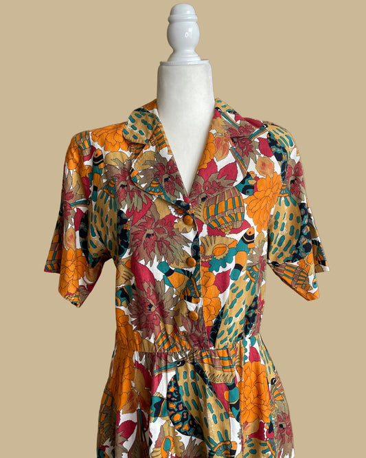Close-up of the shirtdress collar and button front, showing the tropical fish and floral print detail