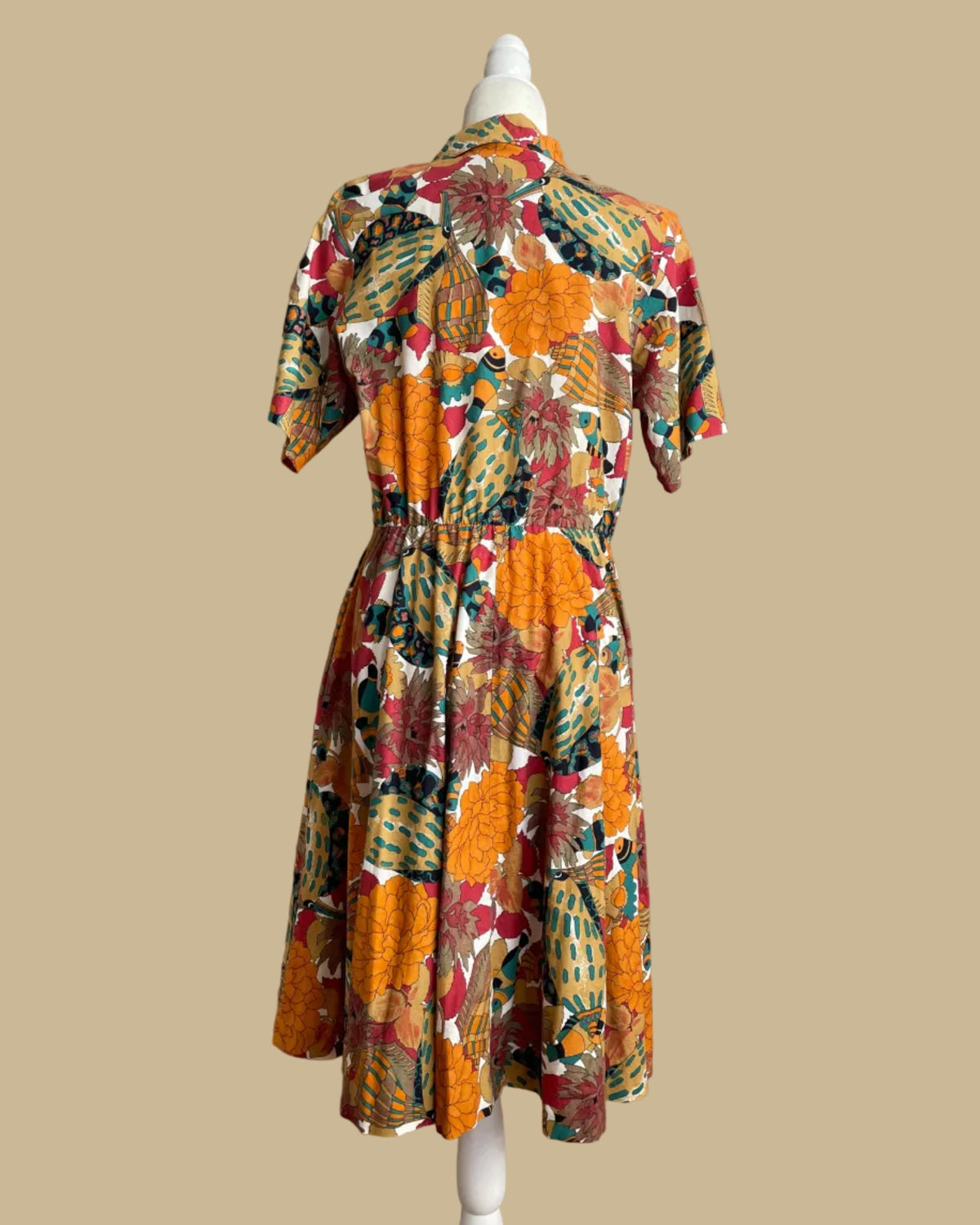 Close-up of the shirtdress fabric texture and print, showing the mustard, teal, coral, and cream color palette