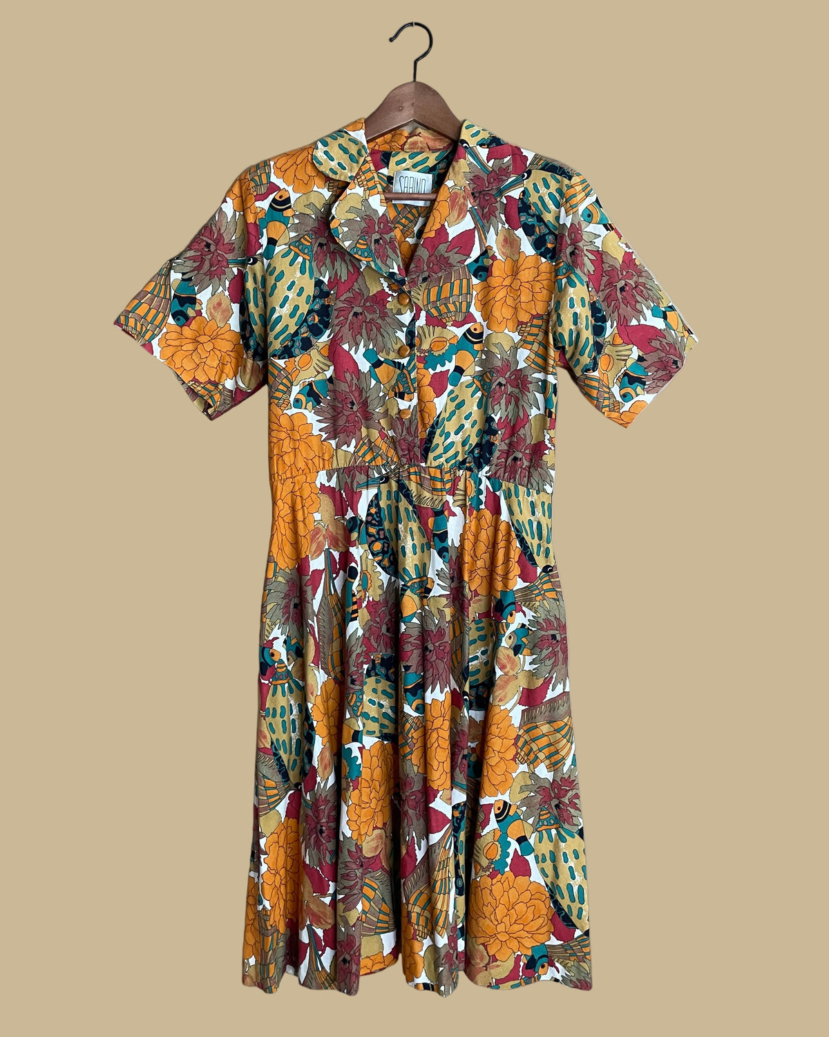 Back view of the shirtdress on a mannequin against a neutral beige background