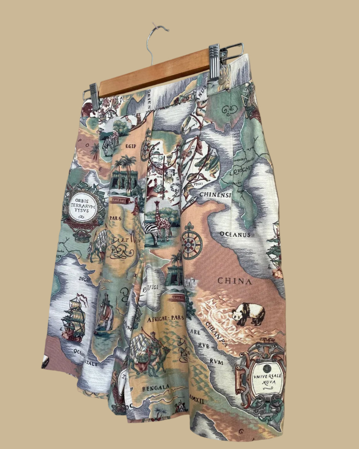 Close-up detail of the map print showing illustrated animals and ships on the shorts fabric
