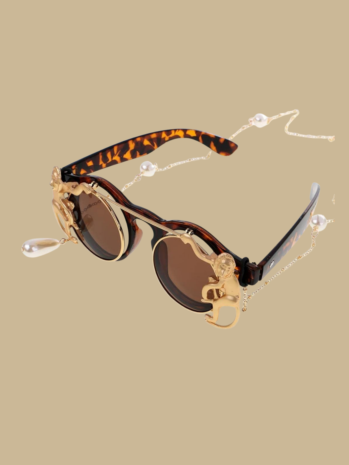 Close-up of the golden monkey detail and pearl chain attachment on the sunglasses