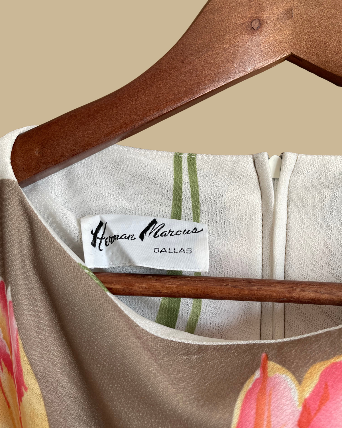 A vintage Herman Marcus tulip print dress in a taupe and cream colorblock with dolman sleeves, shown against a kraft background