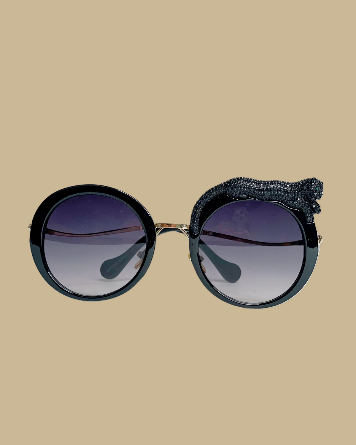 Retro-style sunglasses with a jeweled black cat figure lounging on one side, featuring emerald green jeweled eyes