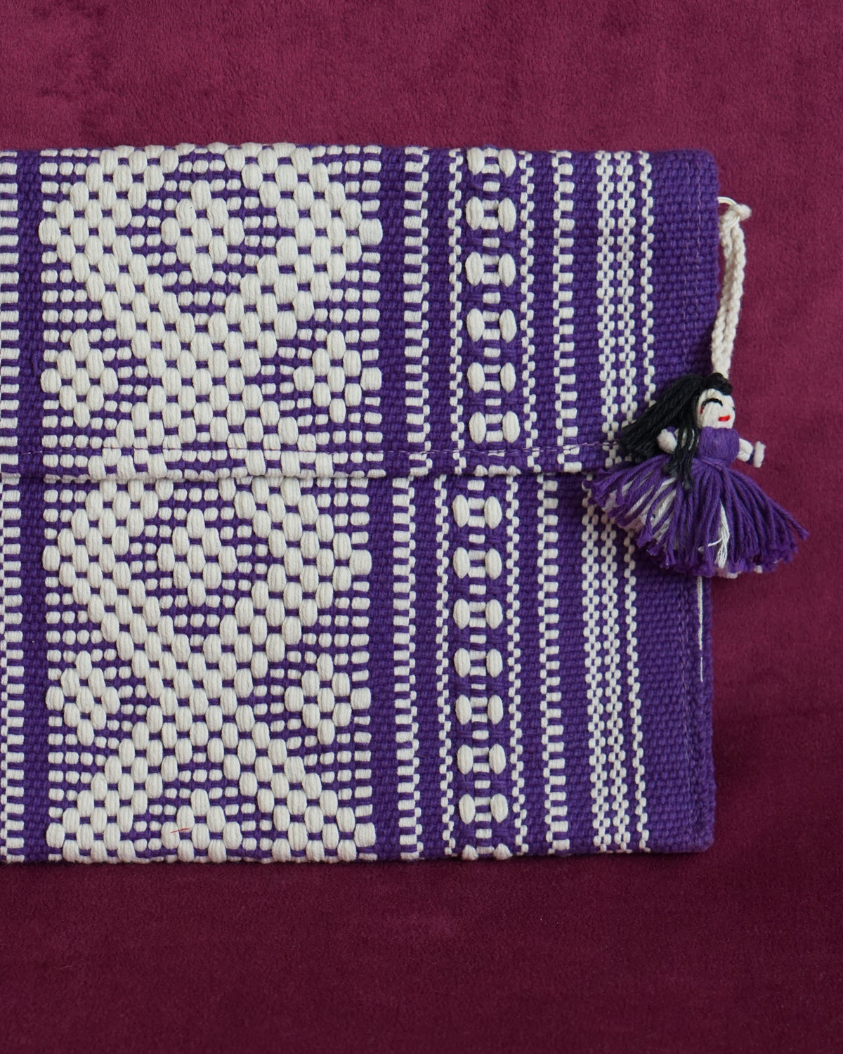 Handwoven cotton clutch in purple and cream with a raised diamond and dot pattern, sourced from Mexico City