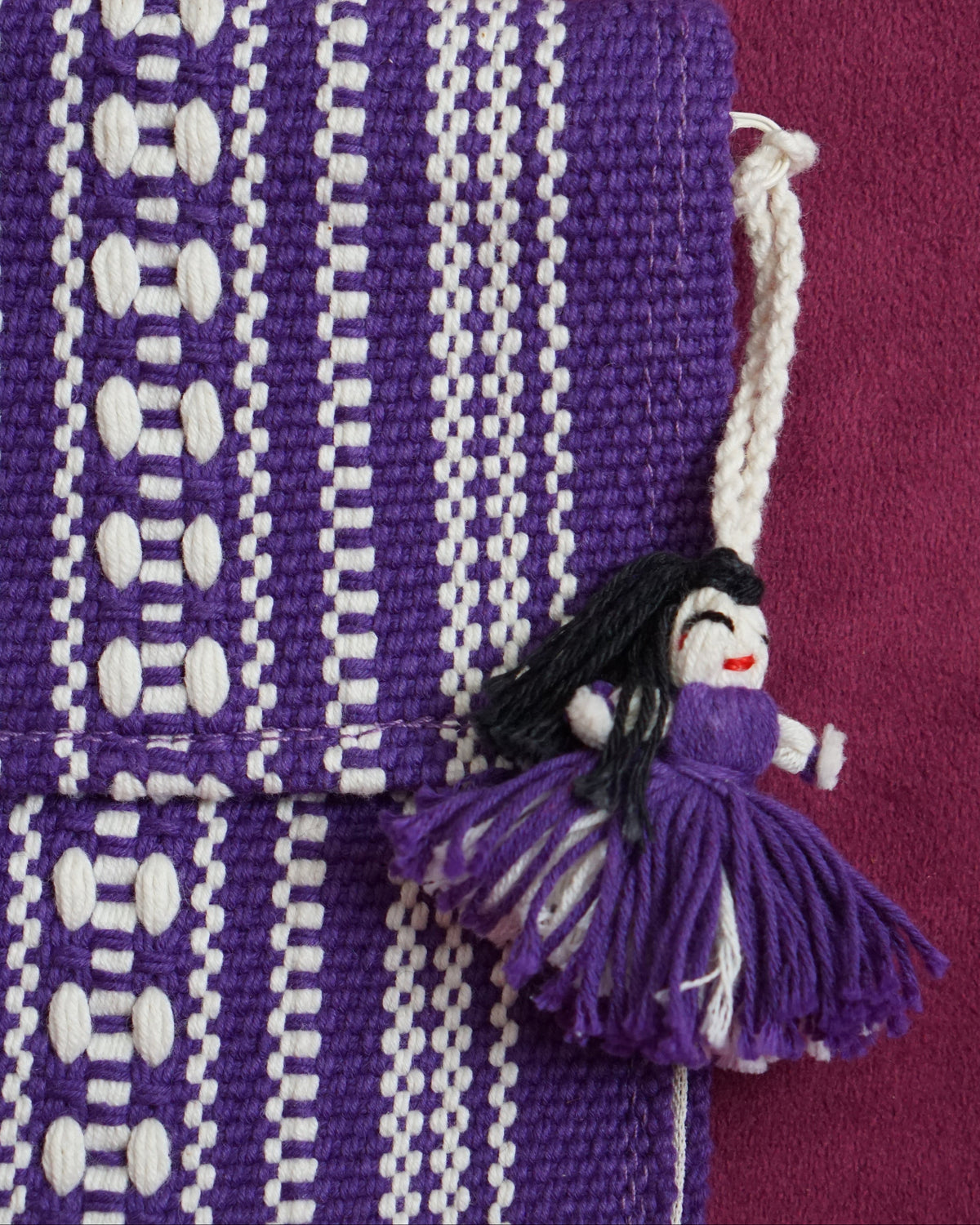Handwoven cotton clutch in purple and cream with a raised diamond and dot pattern, sourced from Mexico City