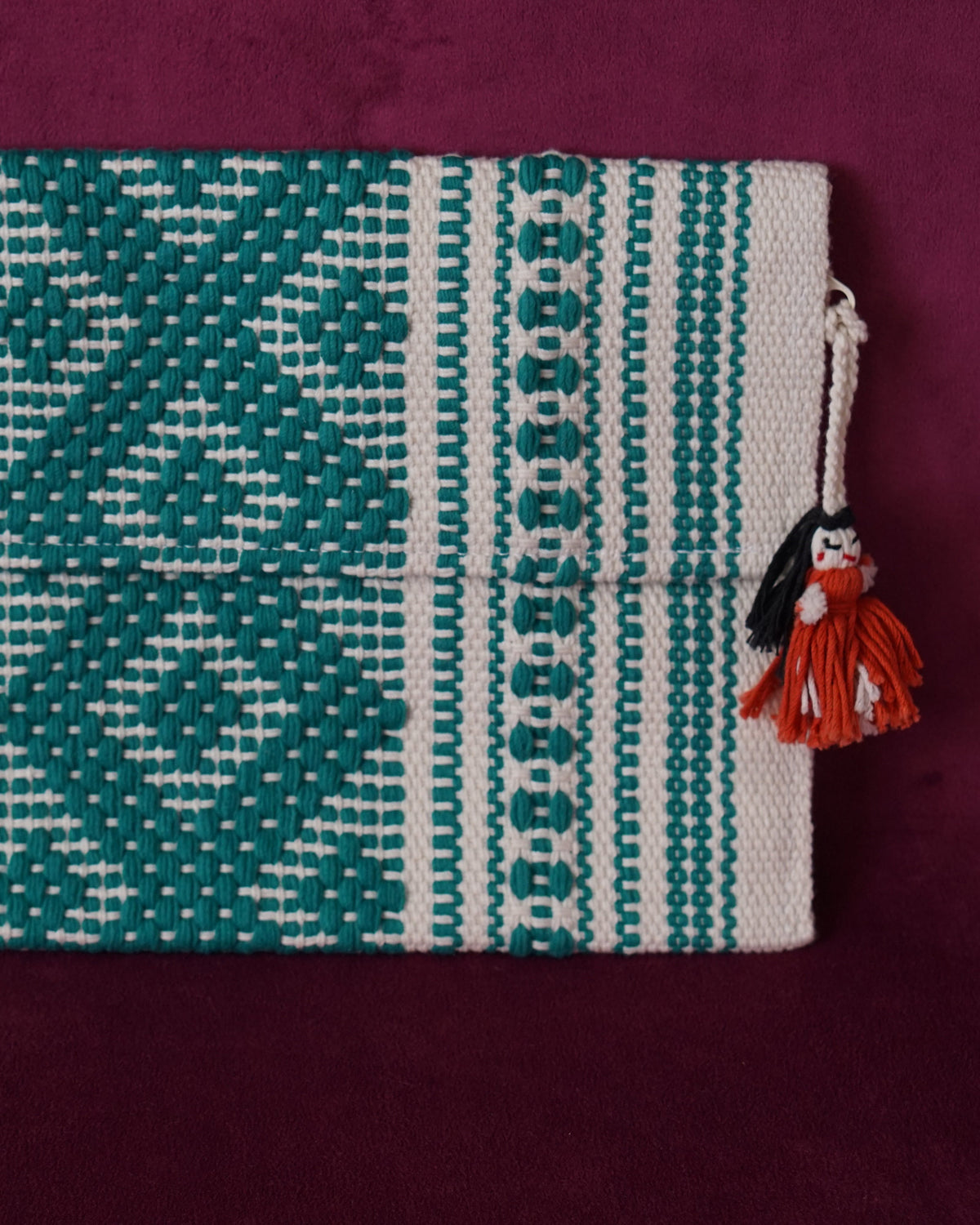 Handwoven cotton clutch in cream and teal with a raised diamond and dot pattern, sourced from Mexico City