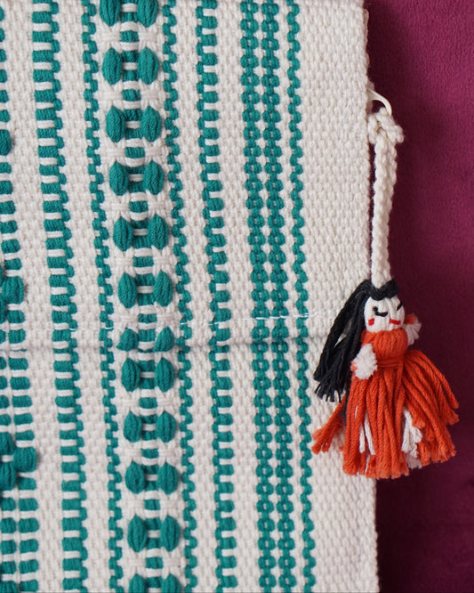 Handwoven cotton clutch in cream and teal with a raised diamond and dot pattern, sourced from Mexico City
