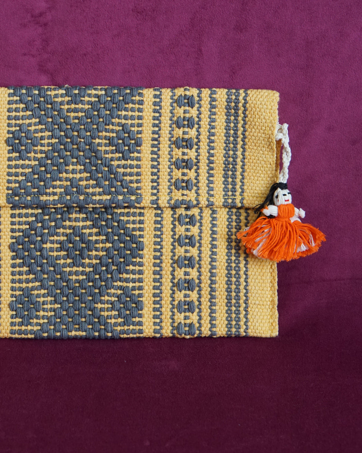 Handwoven cotton clutch in marigold and slate gray with a raised diamond and dot pattern, sourced from Mexico City