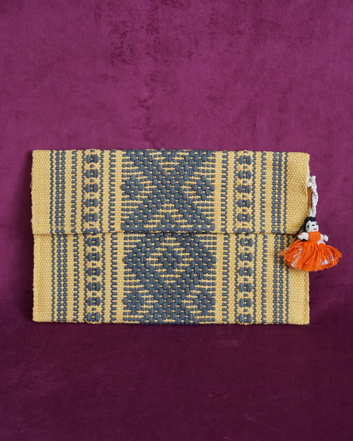 Handwoven cotton clutch in marigold and slate gray with a raised diamond and dot pattern, sourced from Mexico City