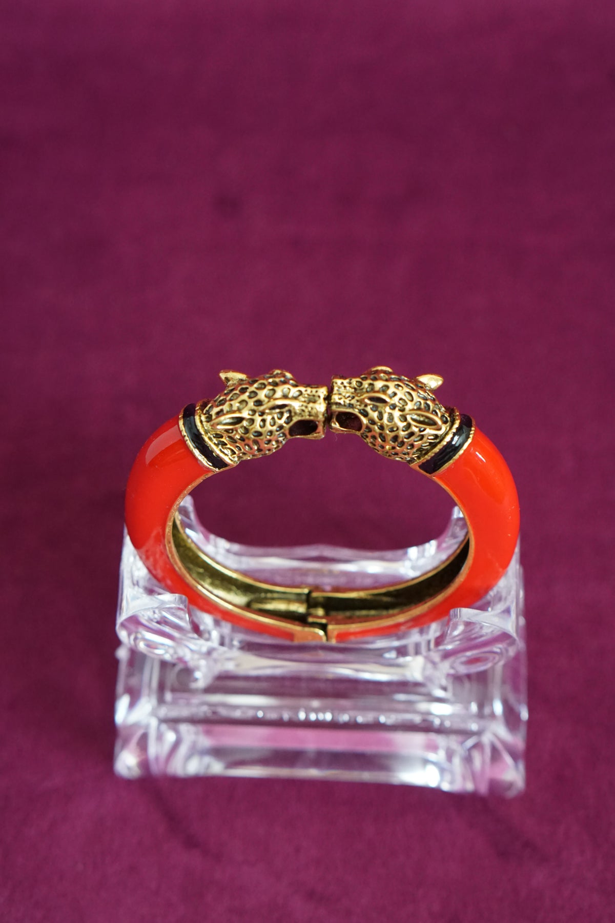 Glossy red enamel hinged bangle capped with two antiqued gold-tone leopard heads