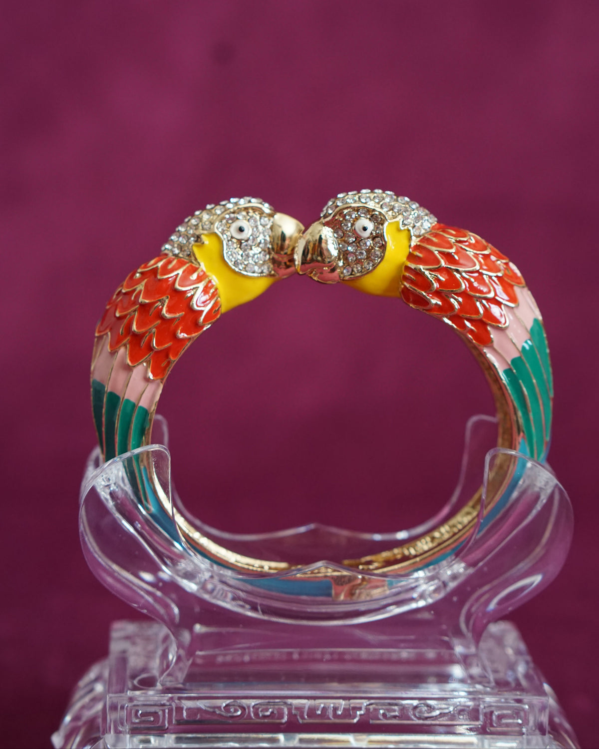 Hinged enamel bangle with two parrots meeting beak to beak, heads paved in sparkling crystals