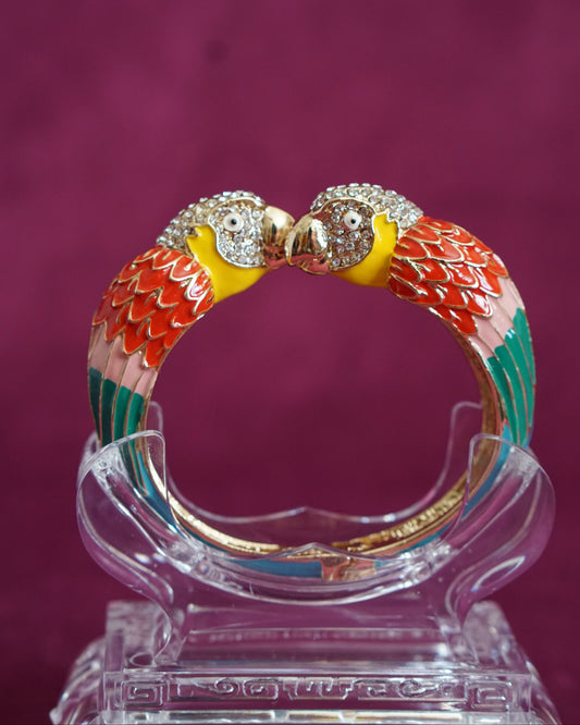 Hinged enamel bangle with two parrots meeting beak to beak, heads paved in sparkling crystals