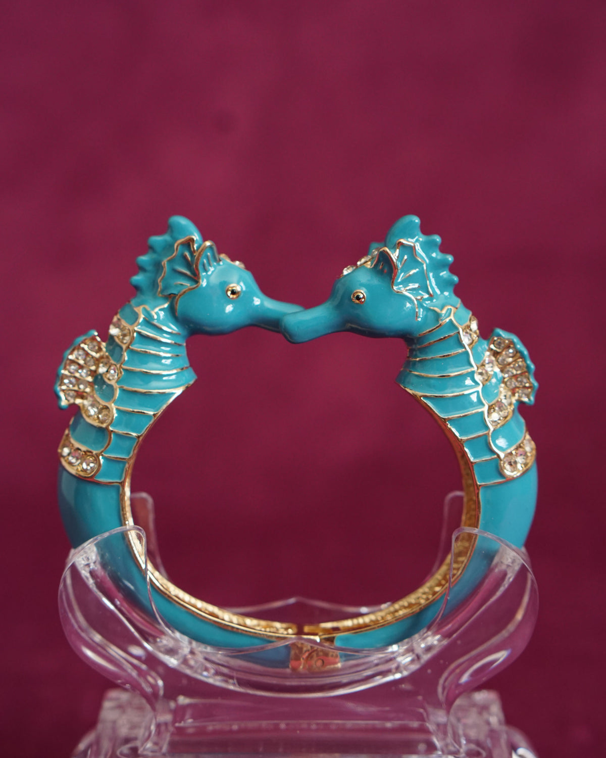 Hinged bangle with two seahorses meeting nose to nose, in bright turquoise enamel