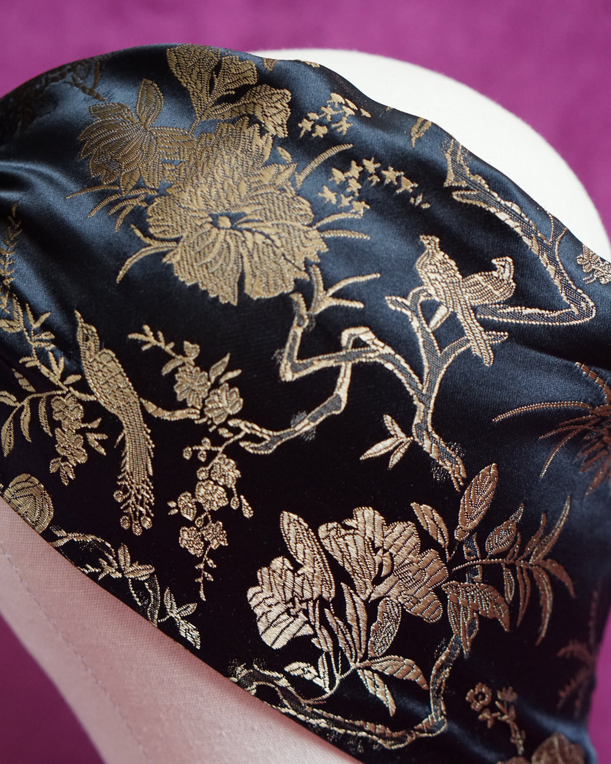 Handmade wired turban headband in black and gold satin brocade woven with perched birds