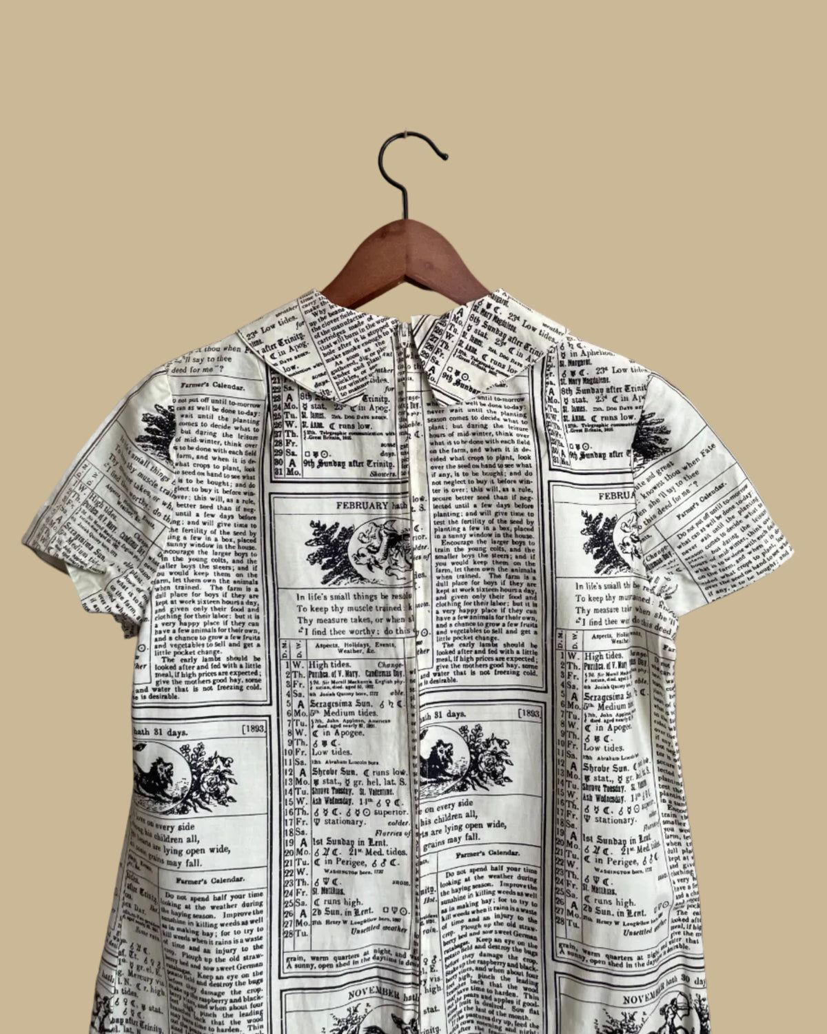 A vintage handmade shift dress with an apple and farmer's-almanac newspaper print, shown against a kraft background