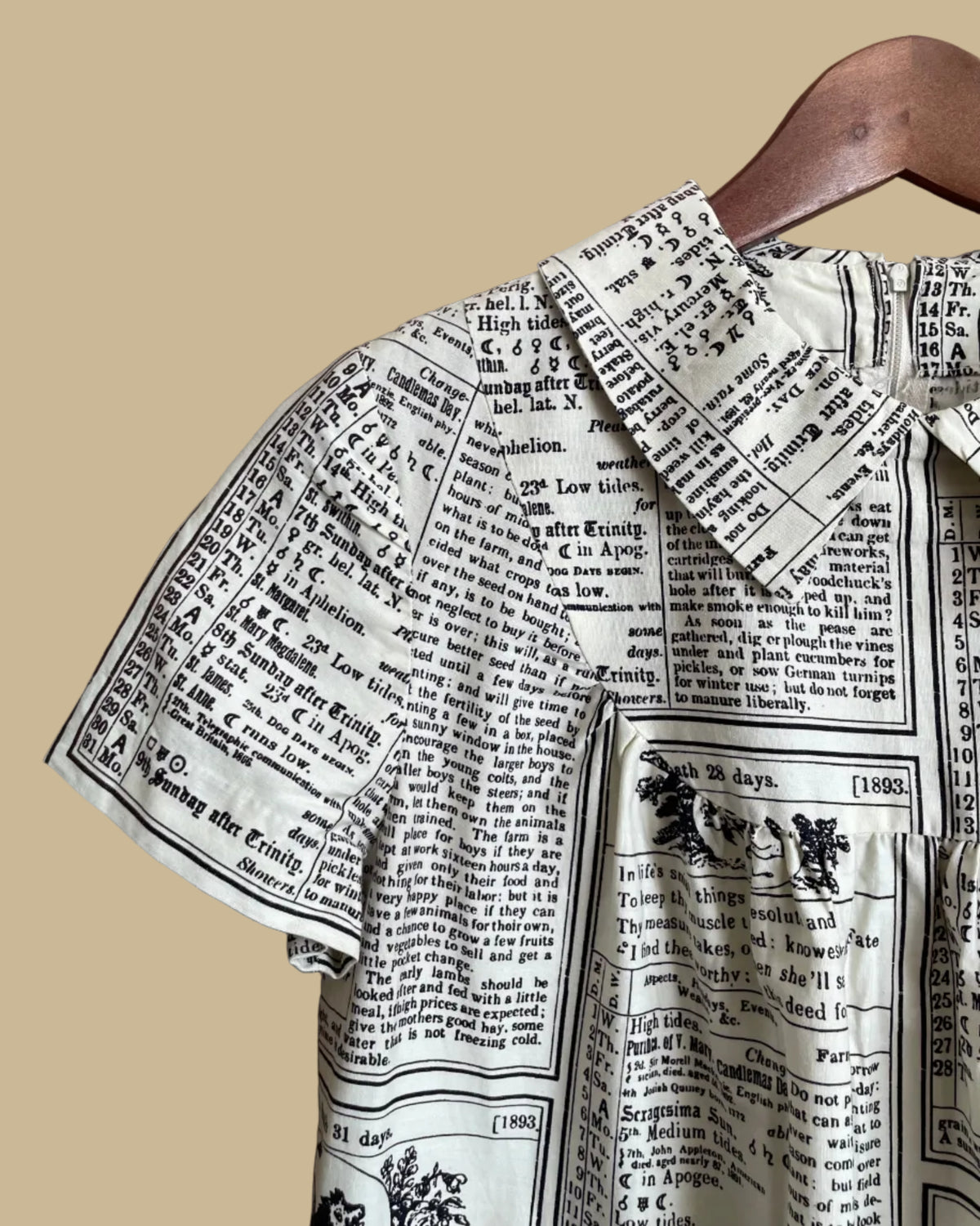 A vintage handmade shift dress with an apple and farmer's-almanac newspaper print, shown against a kraft background