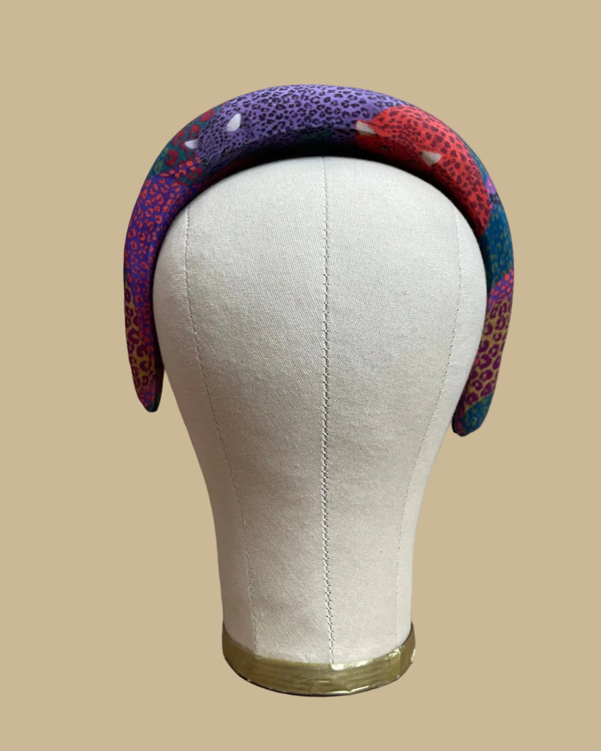 Wide padded Farm Rio headband in a patchwork of jewel-toned leopards in purple, red, teal, and olive