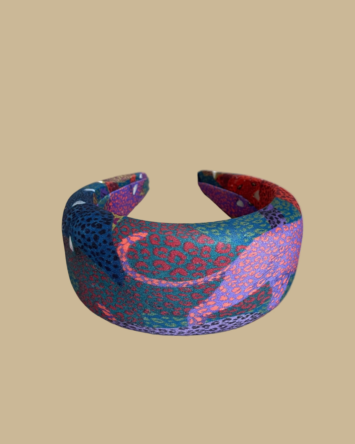 Wide padded Farm Rio headband in a patchwork of jewel-toned leopards in purple, red, teal, and olive
