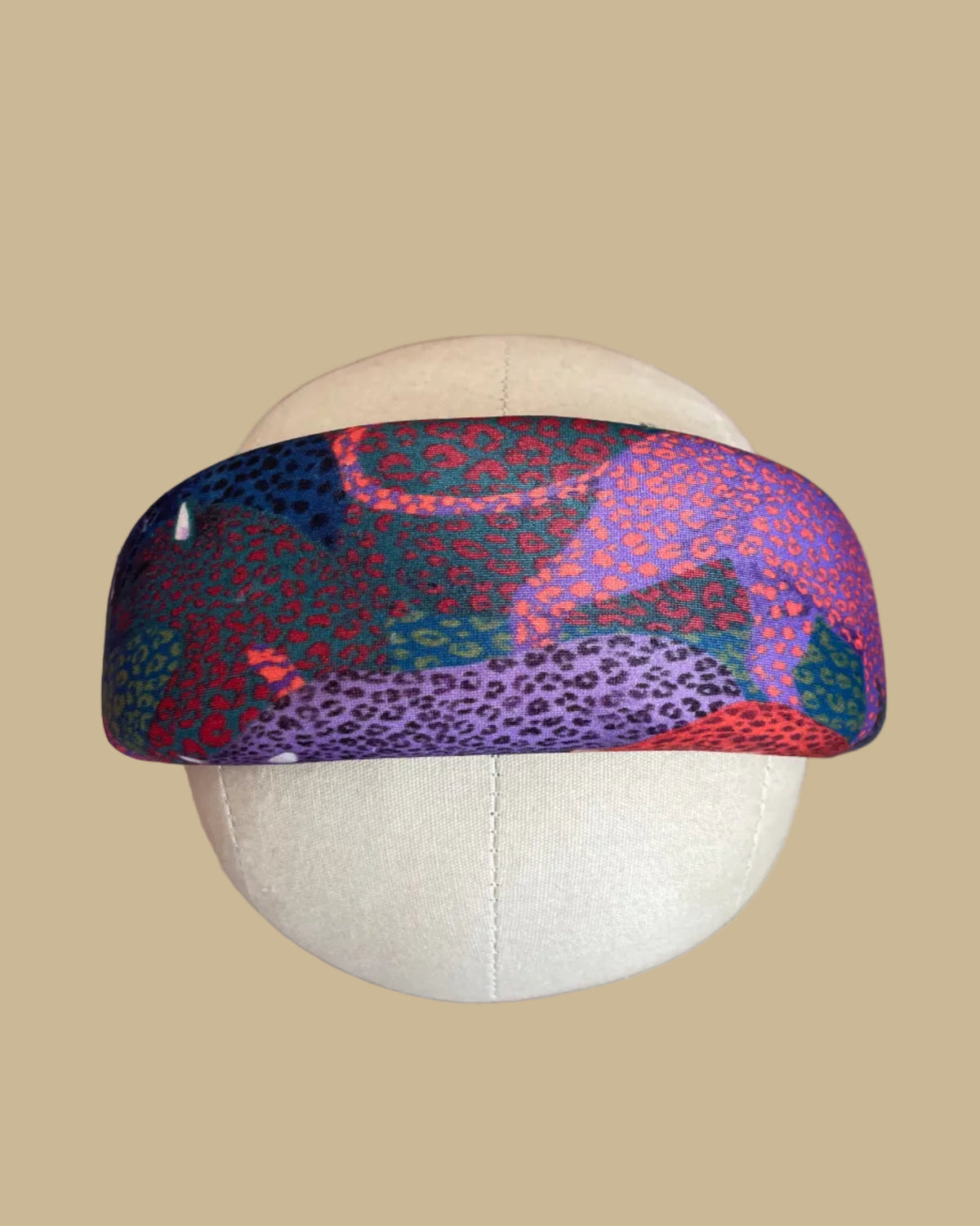 Wide padded Farm Rio headband in a patchwork of jewel-toned leopards in purple, red, teal, and olive