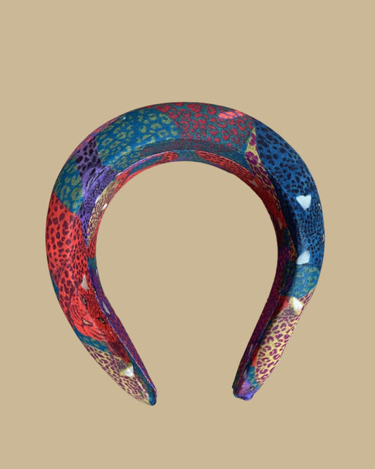 Wide padded Farm Rio headband in a patchwork of jewel-toned leopards in purple, red, teal, and olive