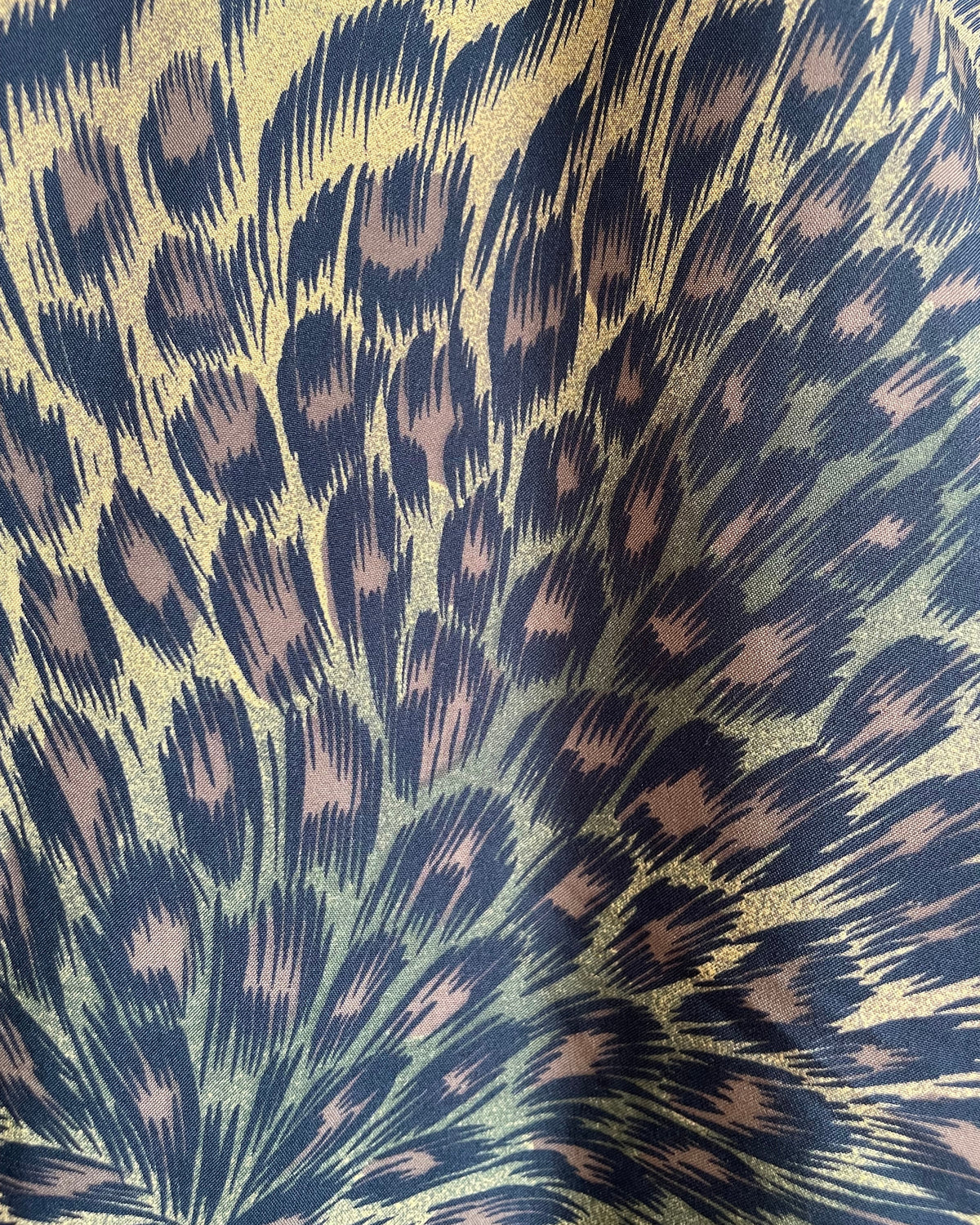 A vintage Leslie Fay double-breasted animal print dress with gold lion-head buttons and epaulette detail, shown against a kraft background
