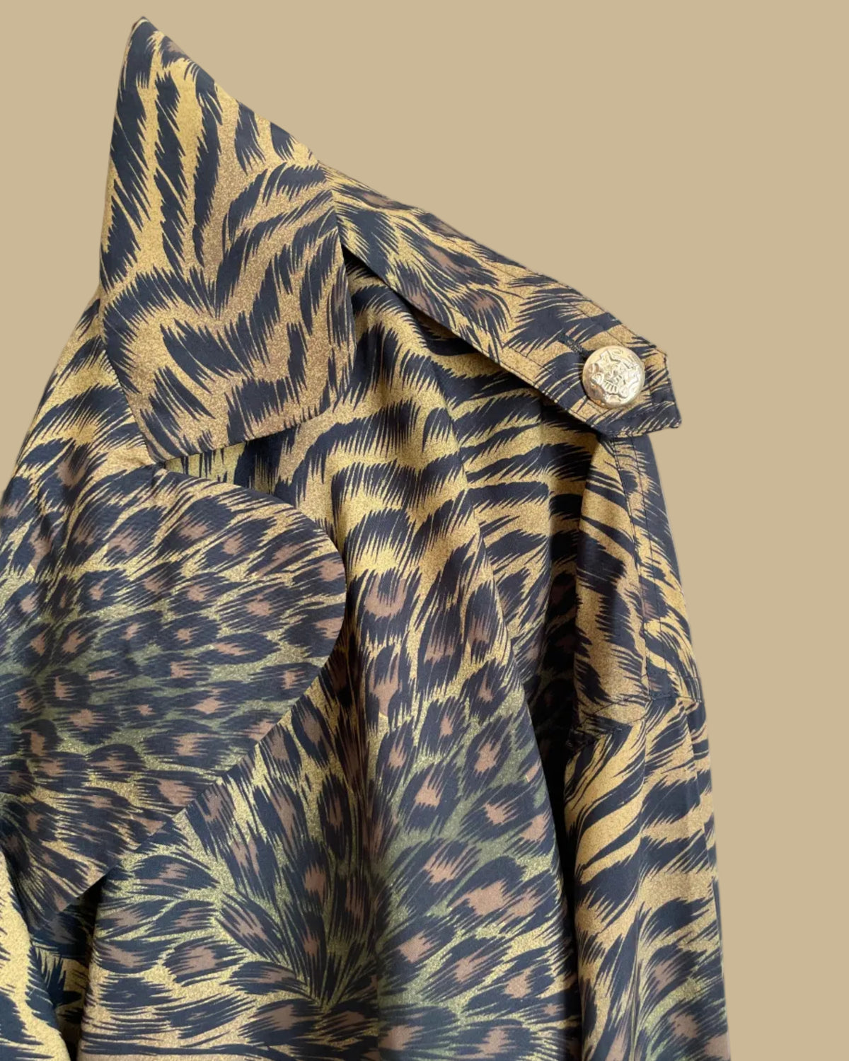 A vintage Leslie Fay double-breasted animal print dress with gold lion-head buttons and epaulette detail, shown against a kraft background