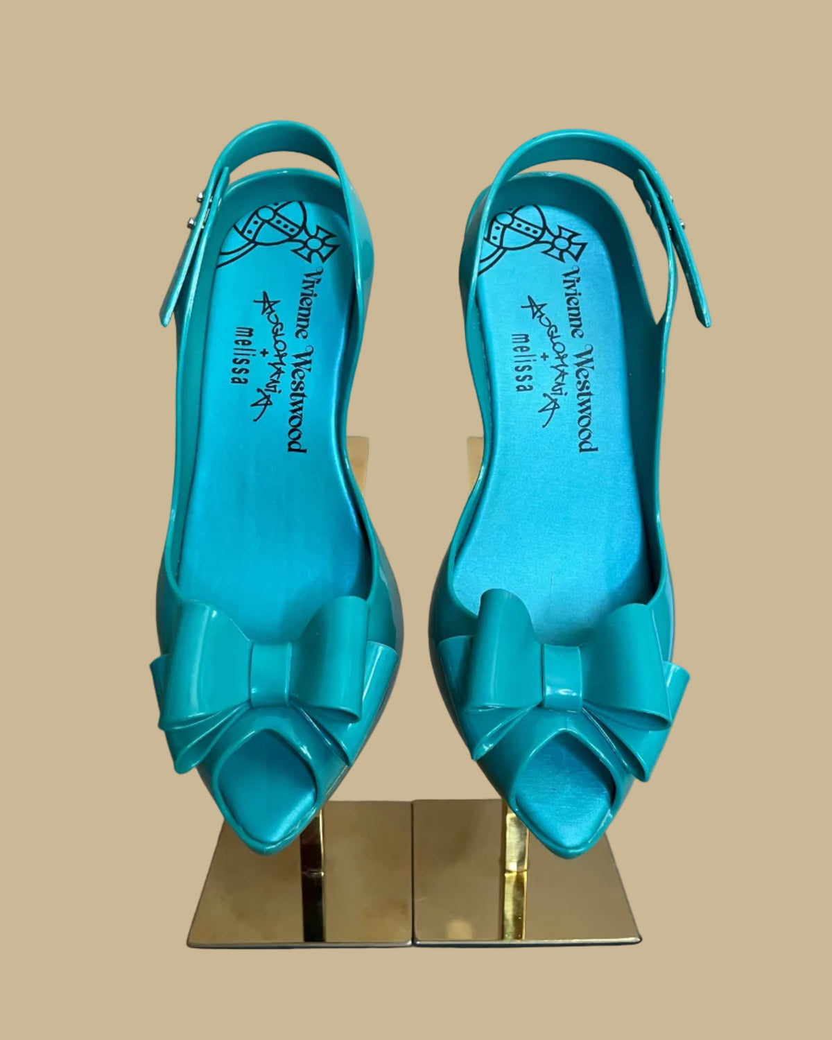 Close-up of the signature bow detail on the teal jelly heels