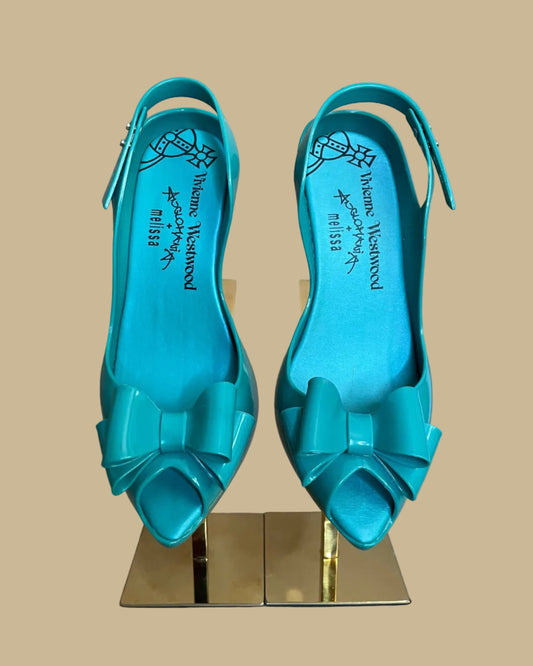 Close-up of the signature bow detail on the teal jelly heels