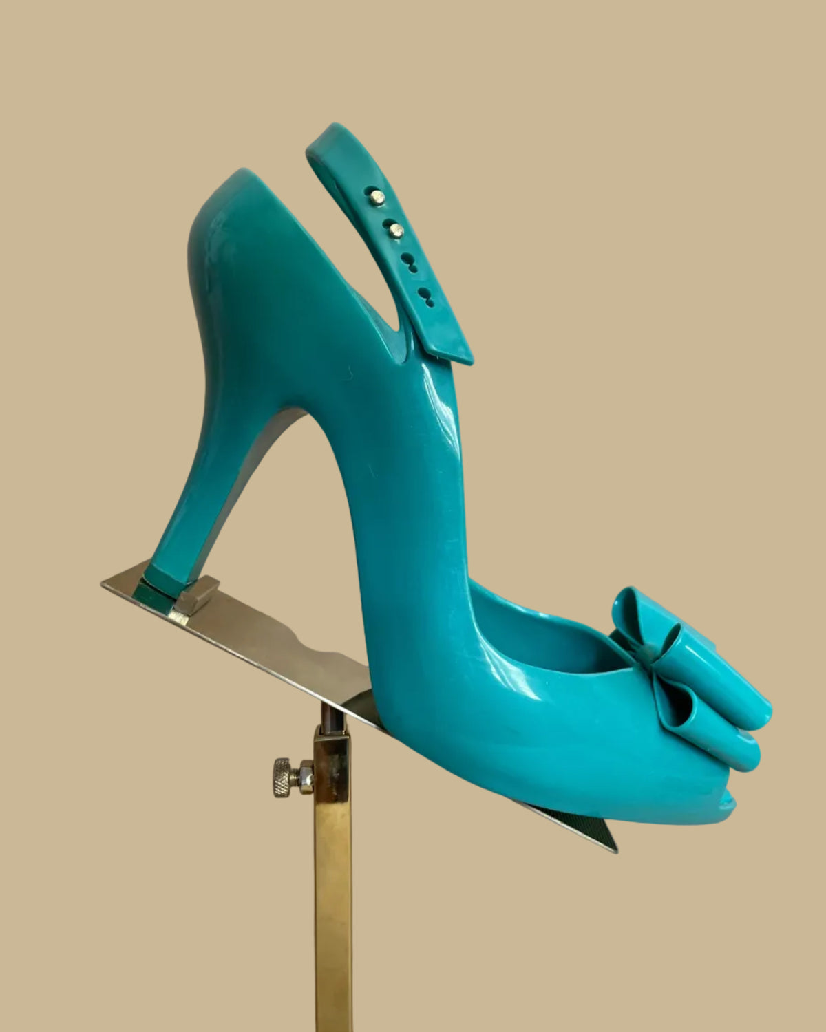 Side view of the teal jelly bow heels showing the ankle strap and buckle closure