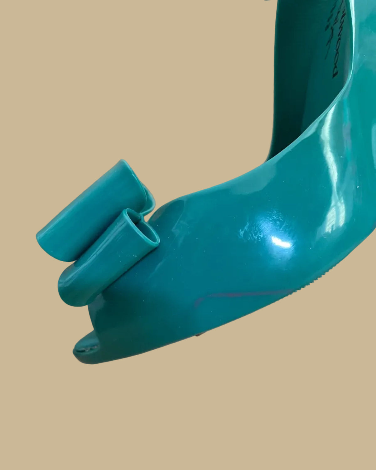 Close-up of the ankle strap buckle closure on the teal jelly heels