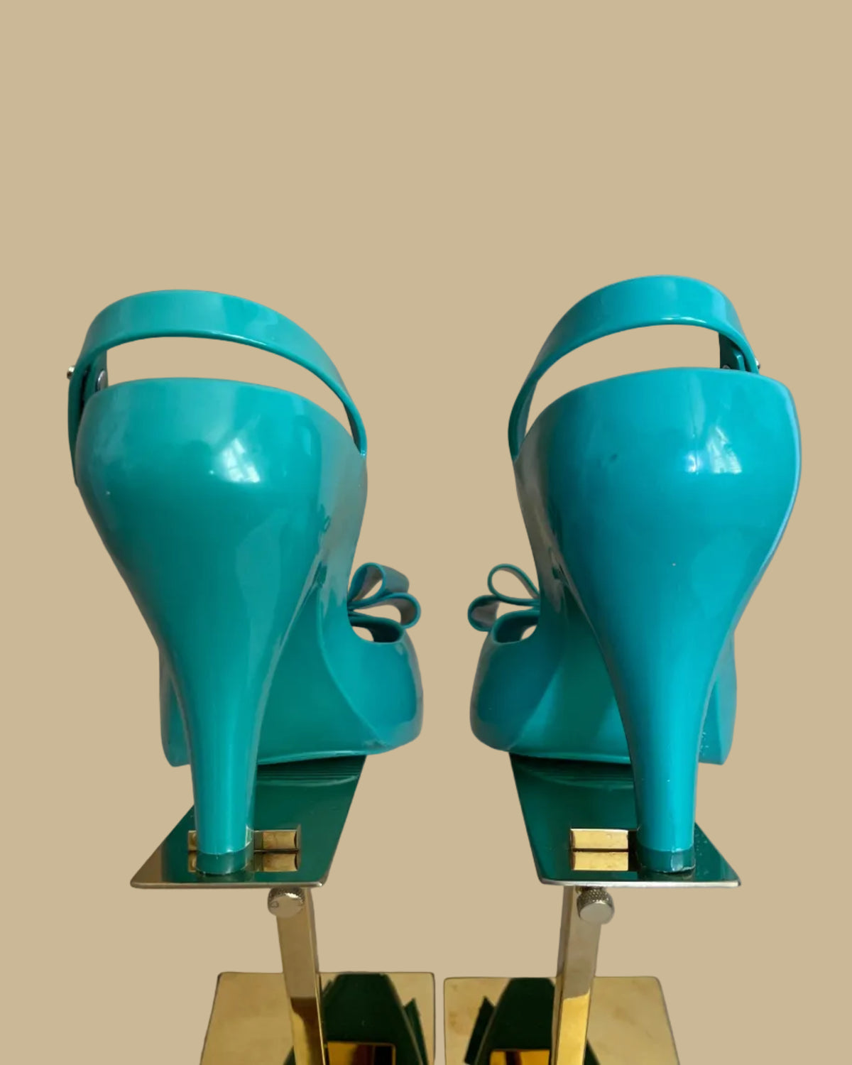 Back view of the teal jelly bow heels on gold stands
