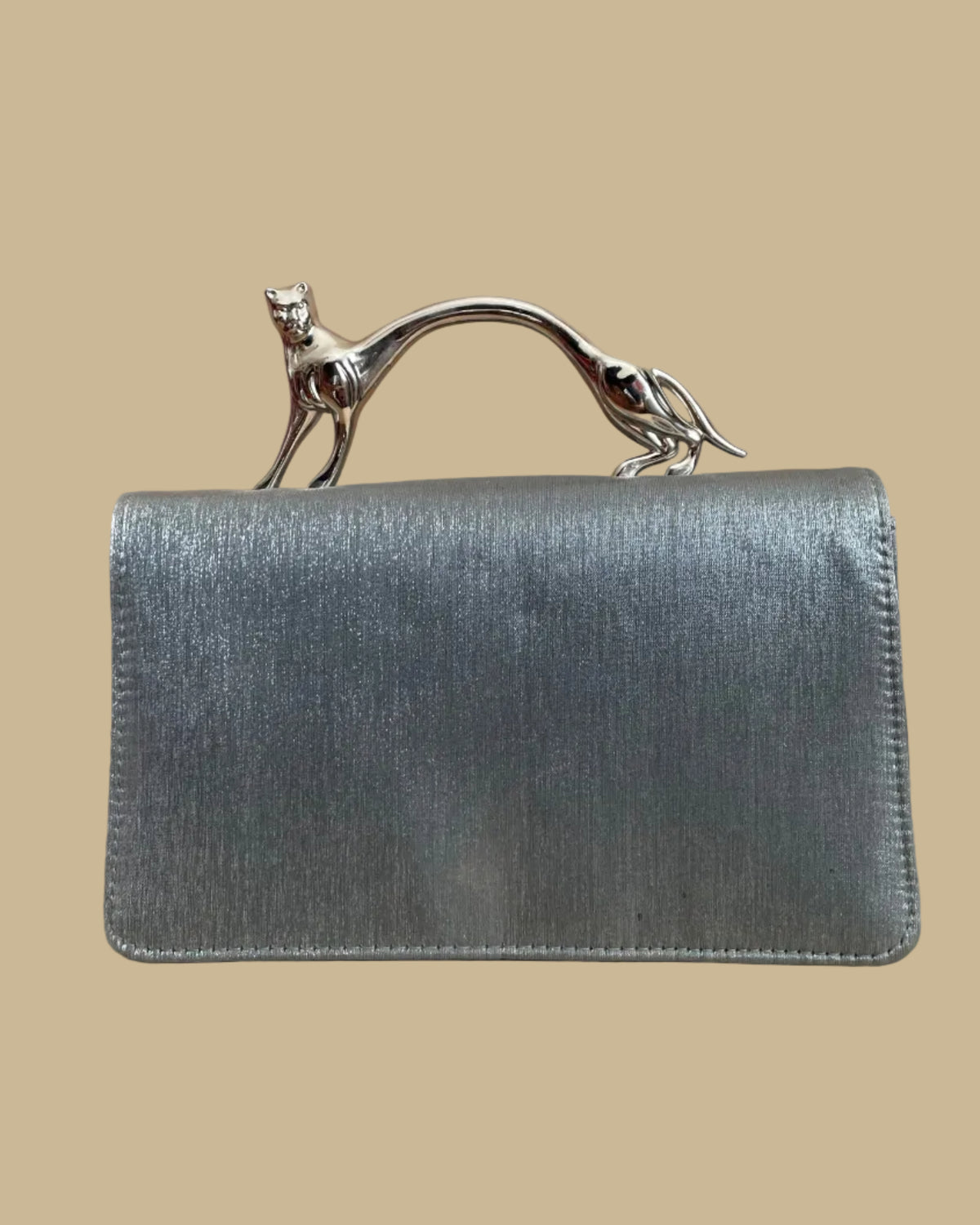 Pewter-silver metallic evening bag with a polished chrome feline handle across the flap