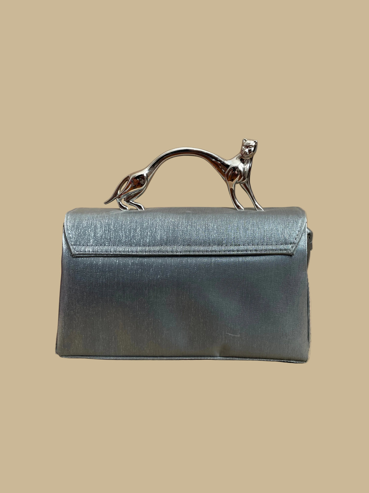 Pewter-silver metallic evening bag with a polished chrome feline handle across the flap