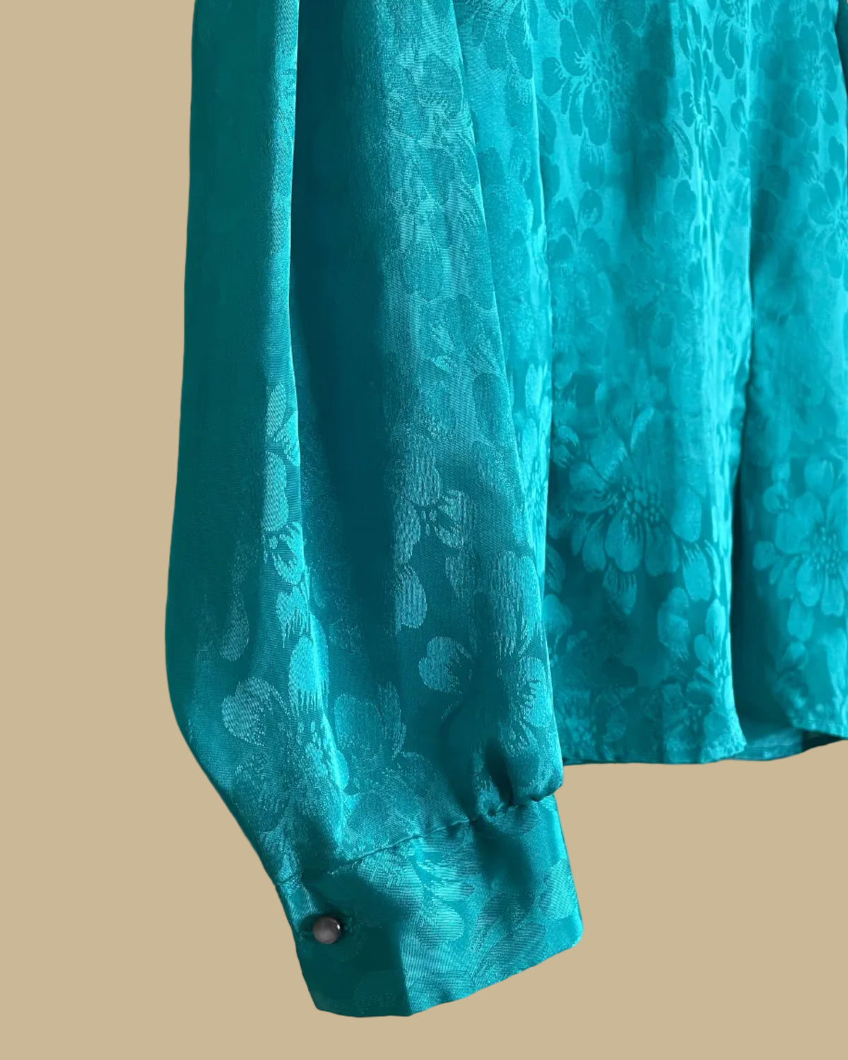Close-up of the crochet lace trim detail at the neckline of the teal blouse