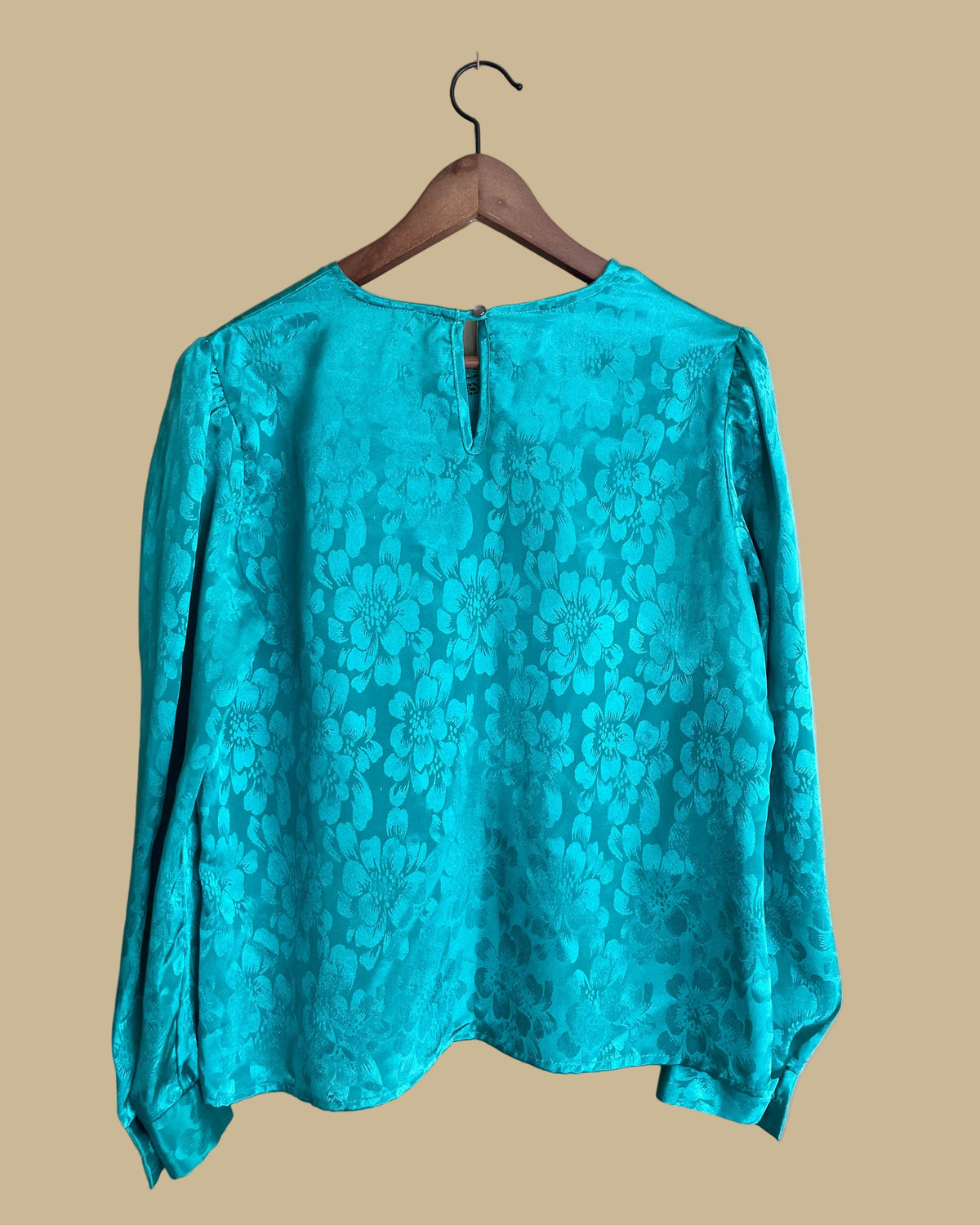 Close-up of the back keyhole button closure on the teal blouse