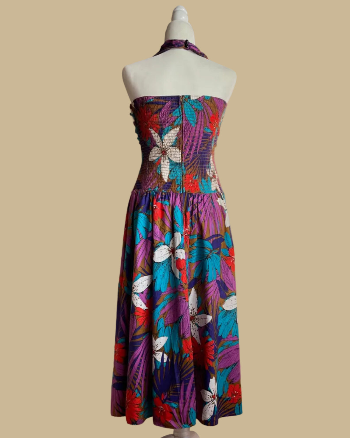 Front view of the tropical floral criss-cross halter dress showing the dropped-waist skirt