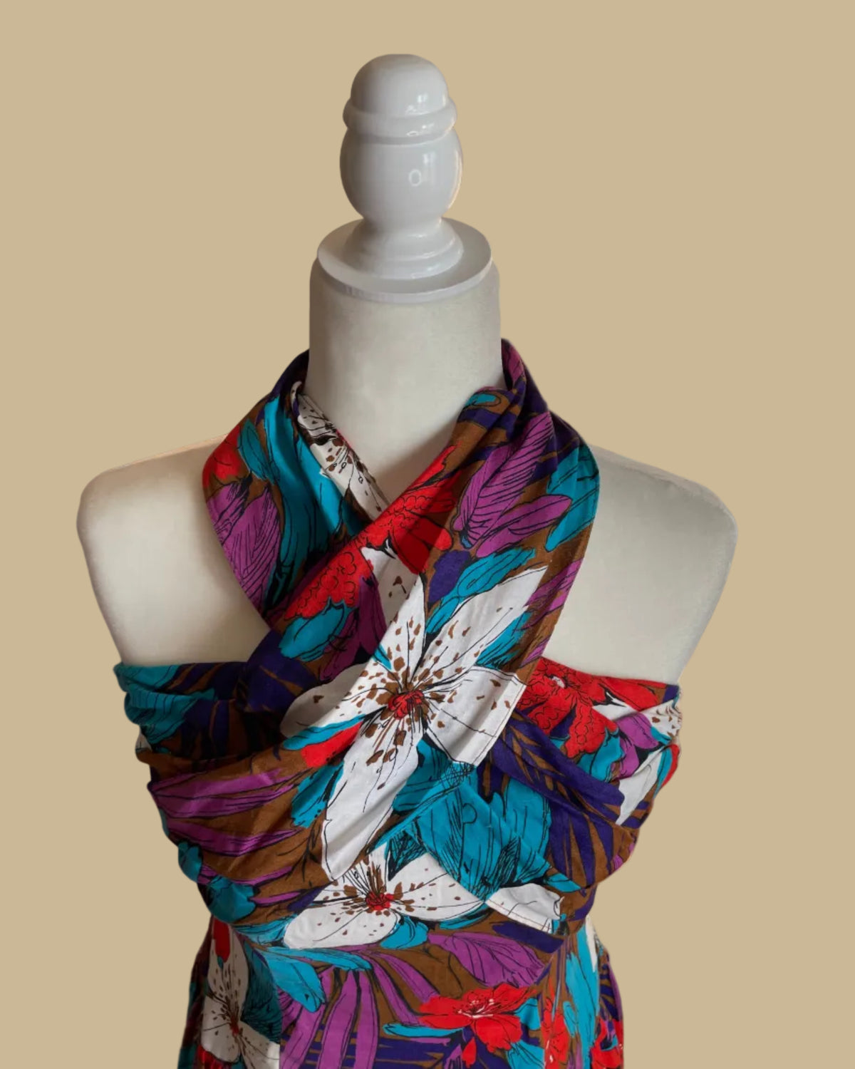 Close-up of the tropical floral print in blue, purple, coral, and white against a brown ground