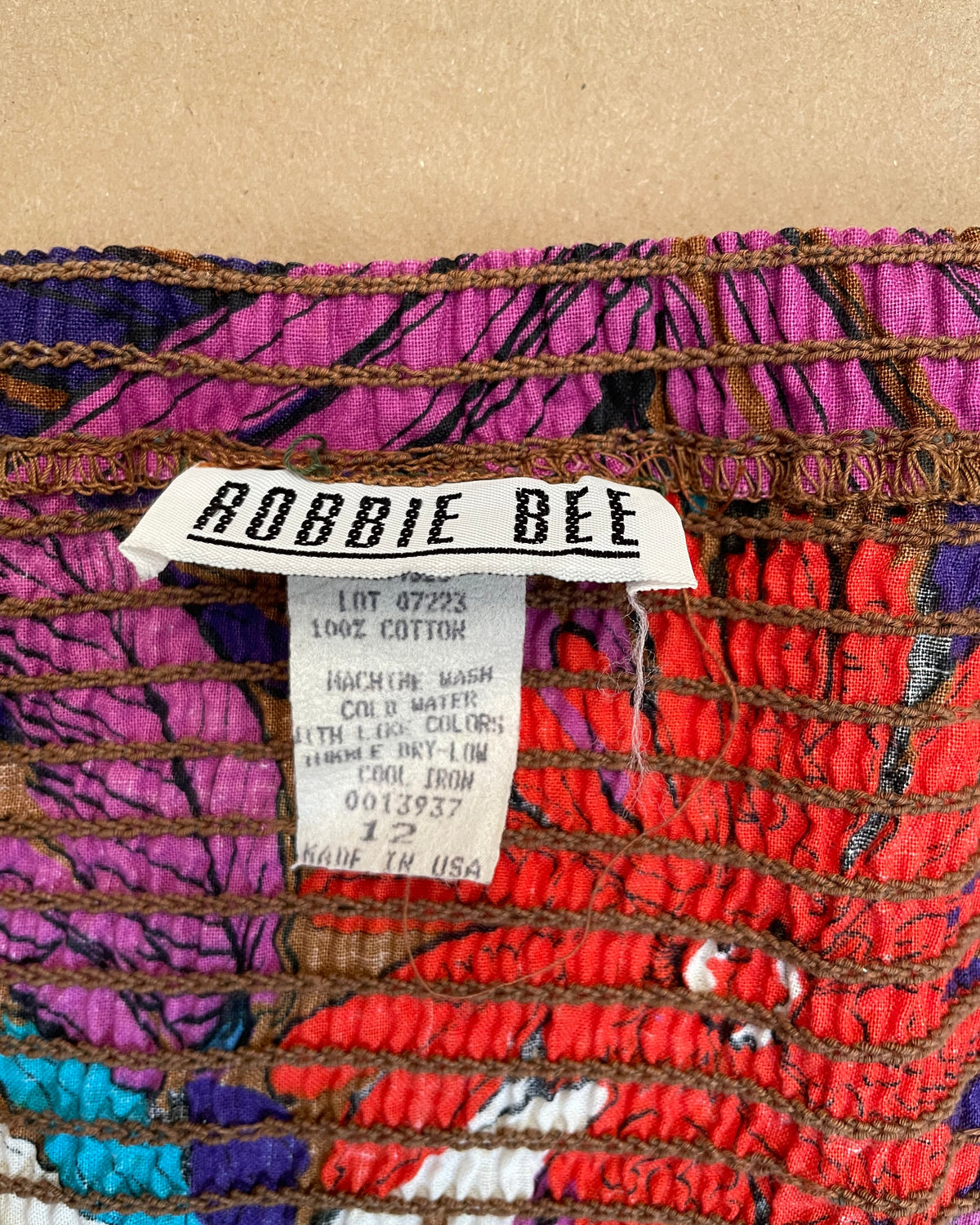 Close-up of the Robbie Bee brand label on the tropical floral halter dress