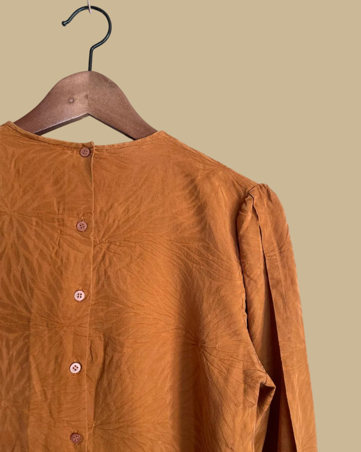 Close-up of the Oleg Cassini brand label inside the rust blouse collar