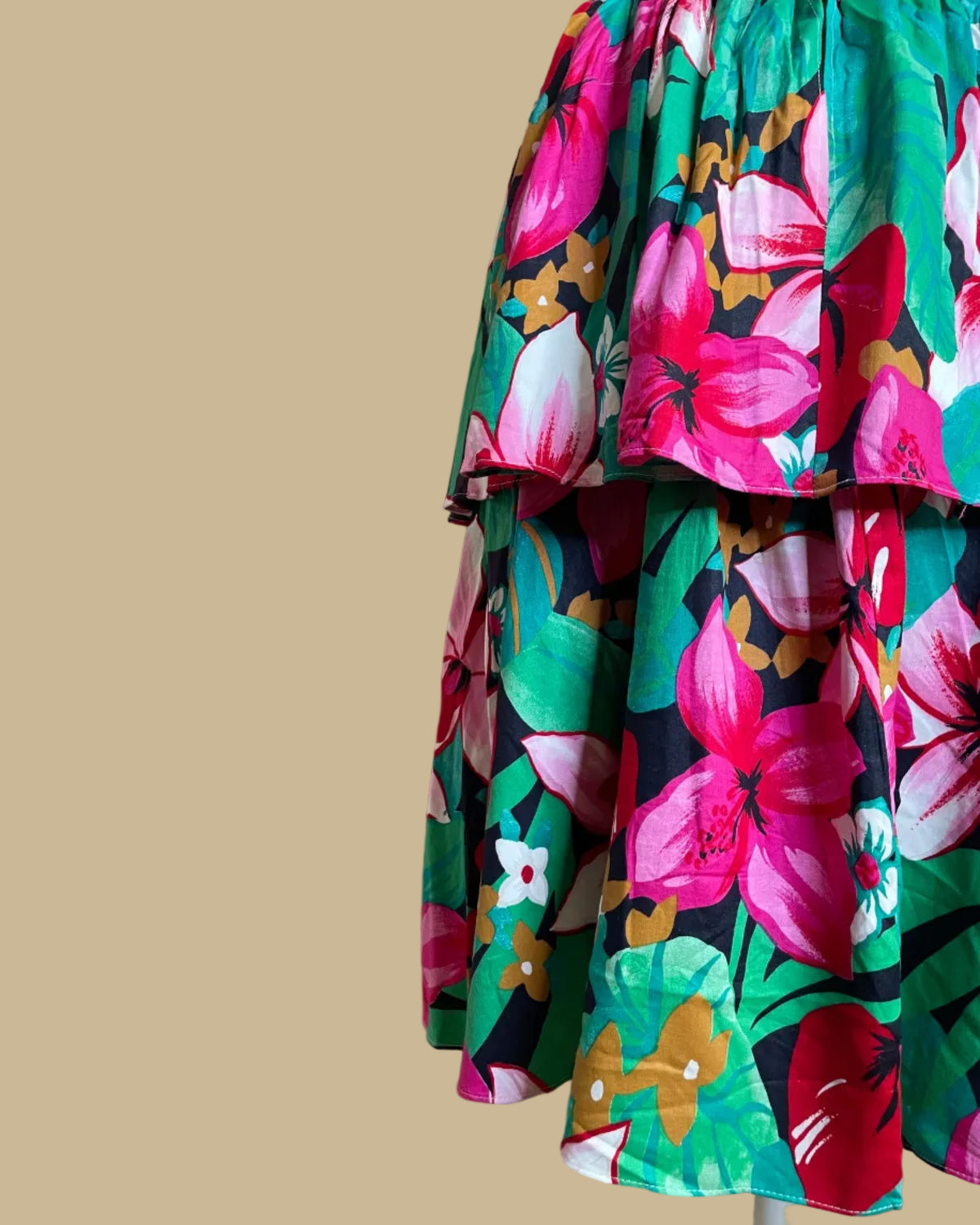 Close-up of the vivid pink, red, and green tropical floral print fabric