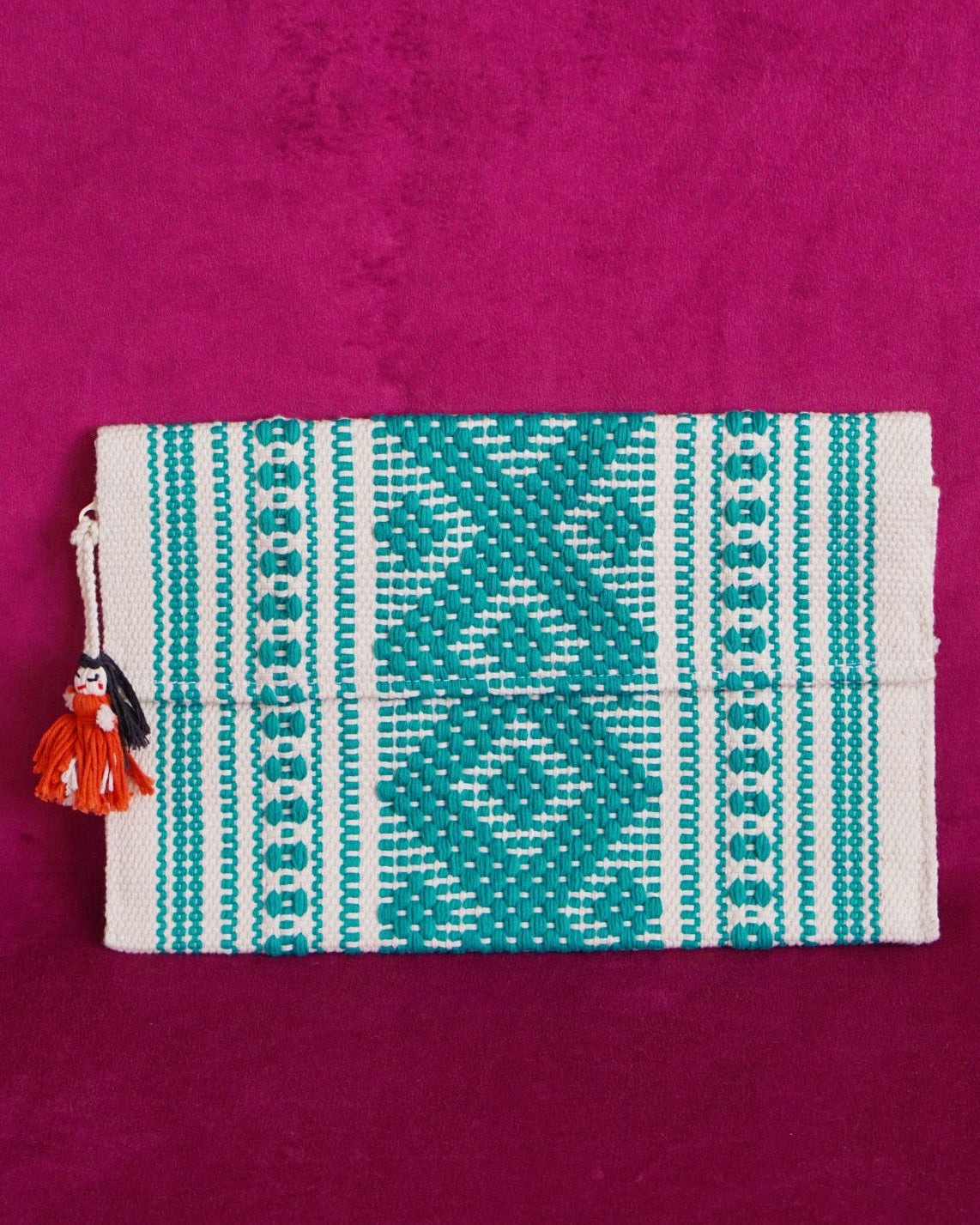 Handwoven cotton clutch in cream and teal with a raised diamond and dot pattern, sourced from Mexico City