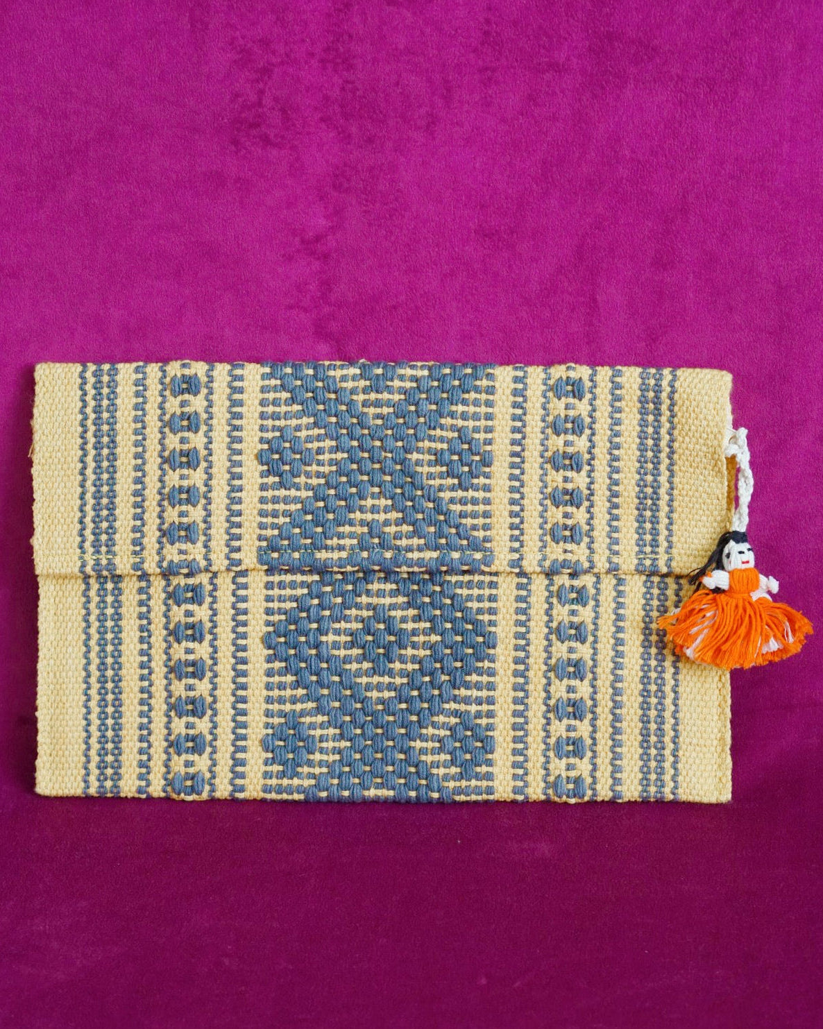 Handwoven cotton clutch in marigold and slate gray with a raised diamond and dot pattern, sourced from Mexico City