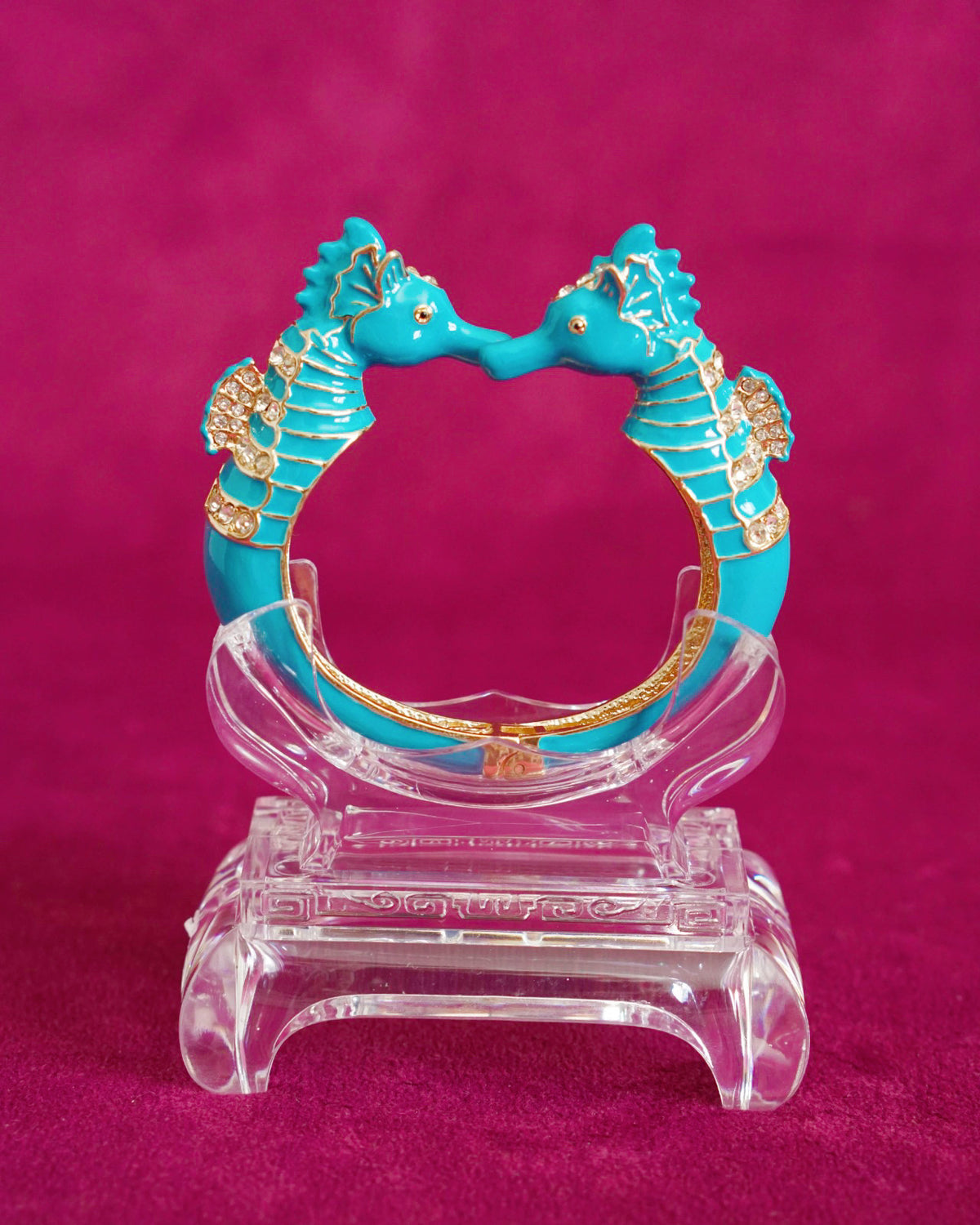 Hinged bangle with two seahorses meeting nose to nose, in bright turquoise enamel